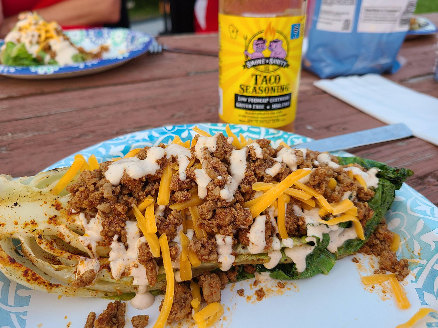 Plate of grilled romaine topped with taco meat and southwest ranch salad dressing