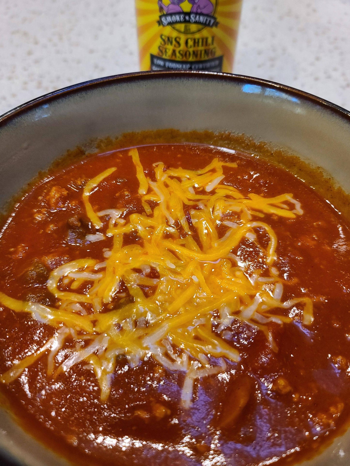 Bowl of chili covered with shredded cheese